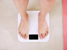 person standing on white digital weight scale