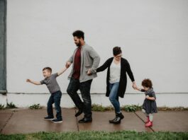 Family Of Four Walking At The Street