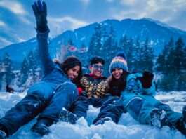 3 women lying on snow covered ground during daytime