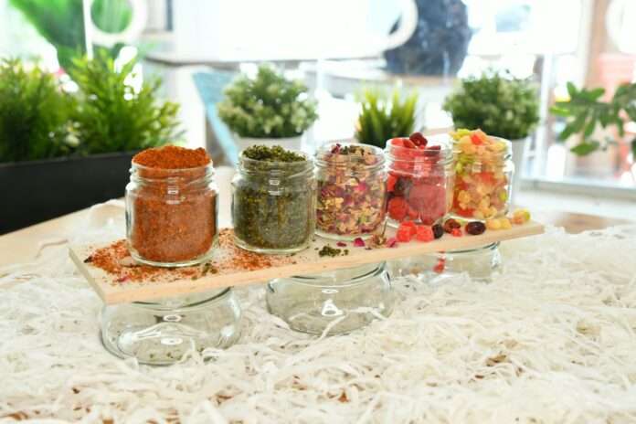 five clear glass jars with assorted spices